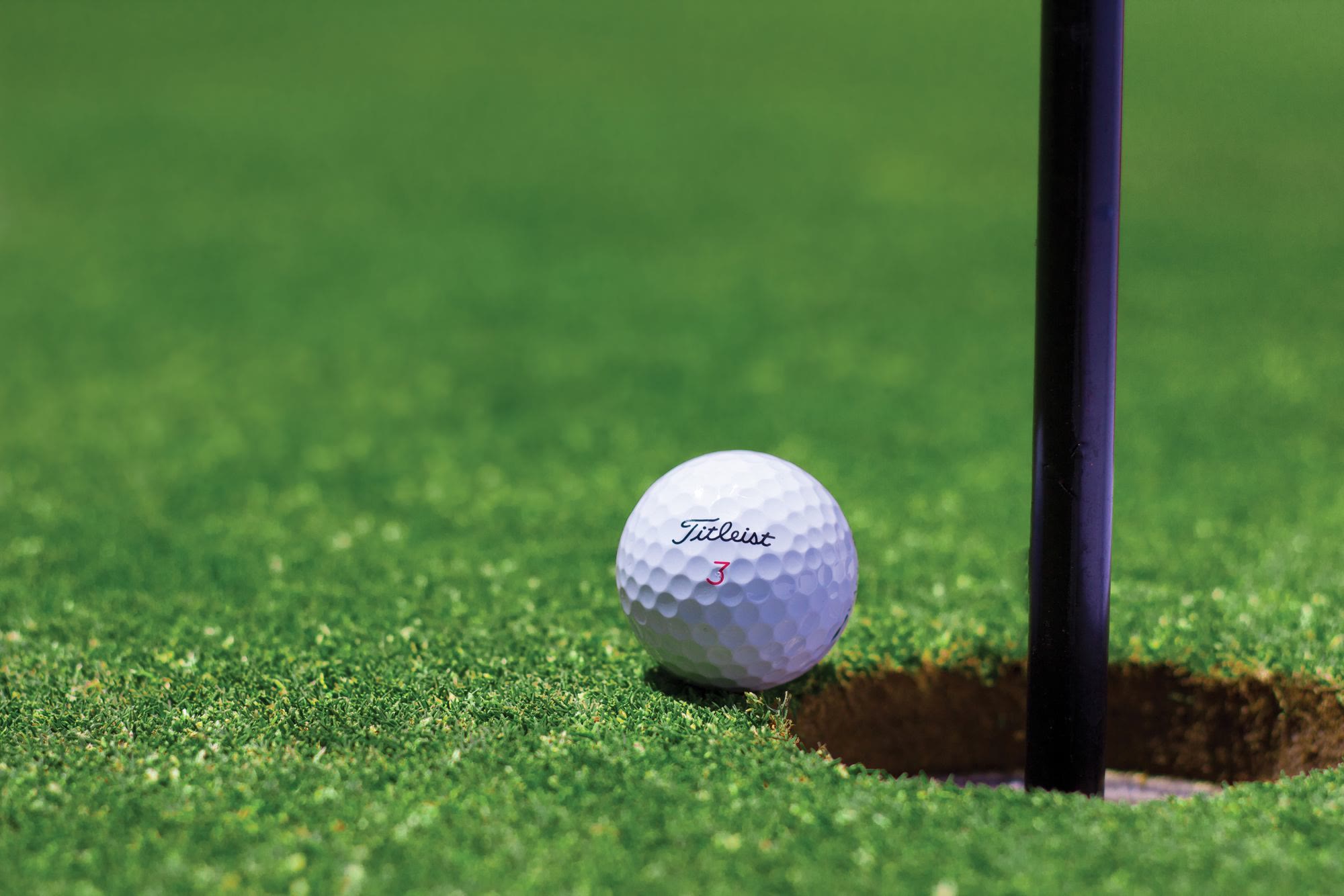 Close-up of a golf ball beside the hole, evocative of Orchid Island's golf course
